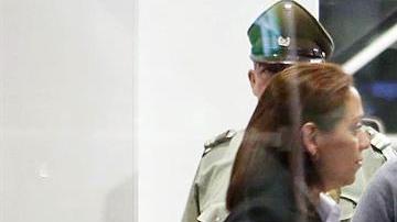 El expresidente de la Asociación Nacional de Fútbol Profesional de Chile, Sergio Jadue (c), en el aeropuerto de Santiago escoltado por la policía para abordar un avión rumbo a Miami junto a su familia.