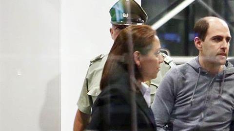 El expresidente de la Asociación Nacional de Fútbol Profesional de Chile, Sergio Jadue (c), en el aeropuerto de Santiago escoltado por la policía para abordar un avión rumbo a Miami junto a su familia.