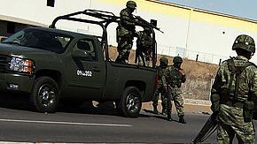 Policías miliatres guardan el lugar donde se cometió un homicidio en Juárez, México.