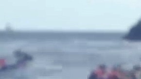 Un socorrista se apresta a ayudar a refugiados que llegan por mar a Grecia.