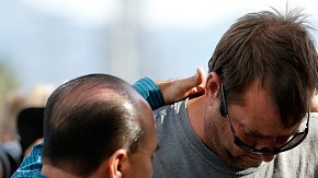 Un grupo de hombres se abrazan afuera del Inland Resource Center en San Bernardino, donde una pareja armada ultimó a 14 personas e hirió a muchas más. (Getty Images)