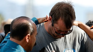 Un grupo de hombres se abrazan afuera del Inland Resource Center en San Bernardino, donde una pareja armada ultimó a 14 personas e hirió a muchas más. (Getty Images)