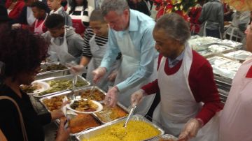 El alcalde Bill de Blasio junto al reverendo Al Sharpton reparten comida a los necesitados.