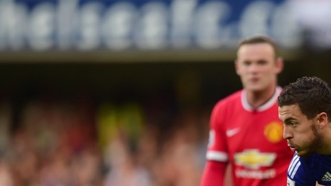 Eden Hazard del Chelsea se quita la marca de Antonio Valencia del Man U ante la mirada de Wayne Rooney.