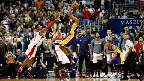 Kobe Bryant dispara sobre Bradley Beal, de los Wizards, para uno de los encestes decisivos en la recta final del partido.