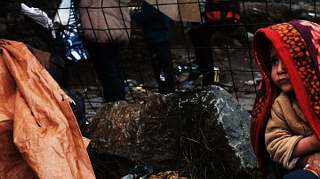 Un hombre y su niña, refugiados de Siria, se cobijan como pueden en la isla de Lesbos, en Grecia