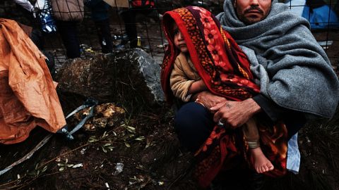 Un hombre y su niña, refugiados de Siria, se cobijan como pueden en la isla de Lesbos, en Grecia