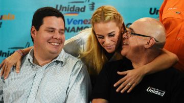 Lilian Tintori, esposa del líder opositor Leopoldo López, felicita al presidente de Movimiento de Unidad Democrática, Jesús 'Chuo' Torrealba (dcha.) y a Juan Carlos Caldera, ex diputado opositor.