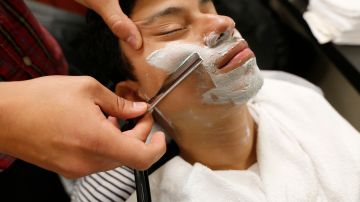 01/25/16 / DOWNEY/ Barber student Max Verderosa, 29, practices the technique blade shaving on fellow student Luis Romero while at Cosmetica School in Downey. (Photo by Aurelia Ventura/La Opinion)