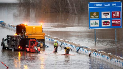 Empleados del Departamento de Transporte de Missouri trabajan para retirar el agua de la autopista I-55 cerca de Arnold.