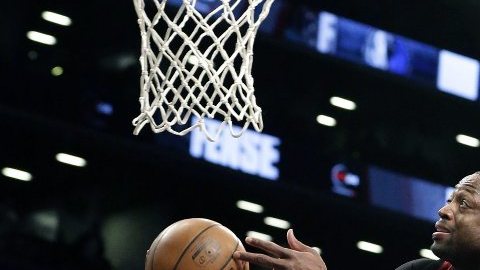 El jugador de Miami Heat Dwyane Wade intenta anotar ante Bojan Bogdanovic de los Nets.