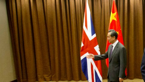 British Foreign Secretary Philip Hammond, right, walks away after shaking hands with Chinese Foreign Minister Wang Yi