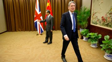 British Foreign Secretary Philip Hammond, right, walks away after shaking hands with Chinese Foreign Minister Wang Yi
