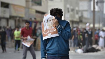 Un manifiestante opositor se enfrenta a la policía en el pueblo de Duraz, Baréin, en la víspera del cuarto aniversario de las protestas que estallaron contra el régimen, el año pasado.