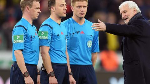 La terna arbitral encabezada por Felix Zwayer, charlando con el director deportivo del Bayer Leverkusen, Rudi Vöeller