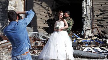 La pareja de recién casados decidió tomar sus fotos de la boda en las calles de la ciudad destruida de Homs, en 
Siria.