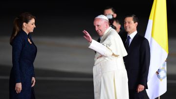 El papa Francisco saluda junto al Presidente de México, Enrique Peña Nieto (R) y la primera dama Angélica Rivera (L) antes de abordar un avión con destino a Roma en el aeropuerto de Ciudad Juárez.