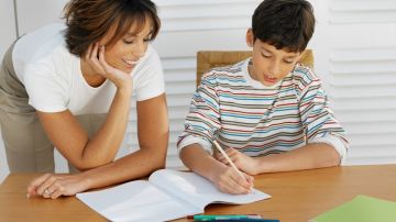Mother helping her son (11-12) with his homework