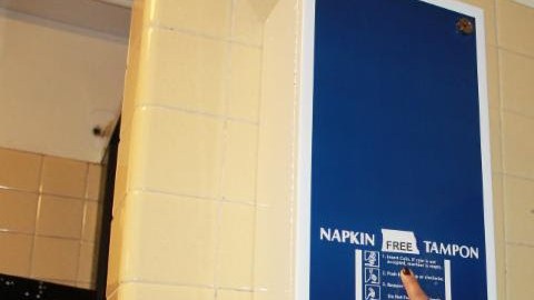 La concejal Julissa Ferreras-Copeland (D-Queens), muestra uno de los dispensadores de toallas sanitarias y tampones gratis instalado en la escuela Newtown High School, en Elmhurst.