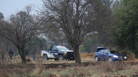 Agentes municipales resguardan la zona donde fueron localizados diez toneles con restos humanos descuartizados y rociados con ácido en el municipio de San Andrés Calpan, en el estado de Puebla, México.