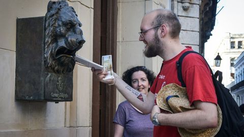 Un turista echa una carta en un buzón en La Habana, Cuba.