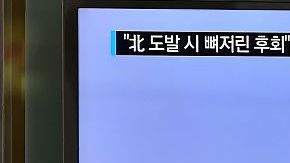 Una mujer pasa junto a un televisor que muestra imágenes de archivo de un misil de Corea del Norte, en Seúl, Corea del Sur.