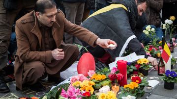 Un hombre enciende una vela en tributo a las víctimas del ataque terrorista en Bruselas.