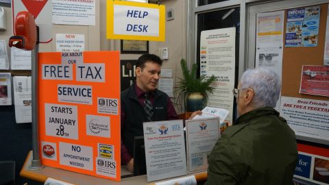 Thomas Neve, director ejecutivo y fundador de Reaching-Out Community Services (Brooklyn) entrega información a usuarios del food pantry sobre el programa gratuito de asesoría de impuestos.
