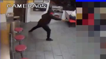 El asaltante enmascarado entró por la puerta principal del restaurante y realizó varios disparos.