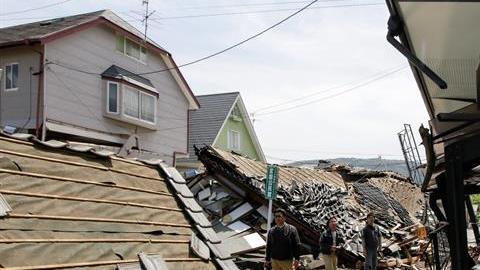 Vecinos caminan entre los escombros tras el terremoto de 6,5 en la escala ritcher en la localidad de Mashiki en la prefectura de Kumamoto (Japón) hoy, 15 de abril de 2016.