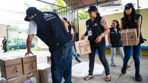 Los empleados de la Oficina Nacional del Perú de Procesos Electorales (ONPE) ordenan material electoral en un colegio en Lima.