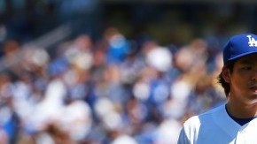 El pitcher Kenta Maeda, de los Dodgers, intercambia opiniones con el catcher A.J. Ellis en la primera entrada del juego inauugural en el Dodger Stadium.