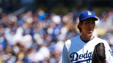 El pitcher Kenta Maeda, de los Dodgers, intercambia opiniones con el catcher A.J. Ellis en la primera entrada del juego inauugural en el Dodger Stadium.