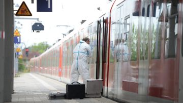Un investigador forense inspecciona un vagón de tren en la estación de Grafing cerca de Múnich (Alemania).