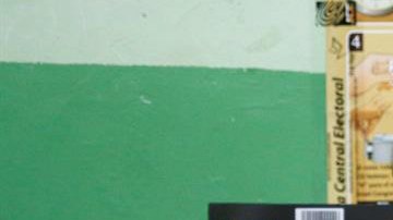 Una vocal de una mesa de votación sostiene un voto durante el conteo tras el cierre de los colegios en Santo Domingo.