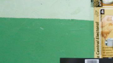 Una vocal de una mesa de votación sostiene un voto durante el conteo tras el cierre de los colegios en Santo Domingo.