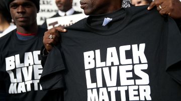 Un protestante sostiene una camiseta con el nombre del movimiento "Black Lives Matter" durante una demostración enfrente del Salón de Justicia de San Francisco en diciembre del 2014. 