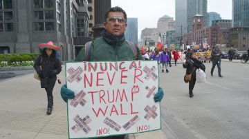 Un manifestante con cartel en mano que reza: “Never Trump Wall en el centro de Chicago”.