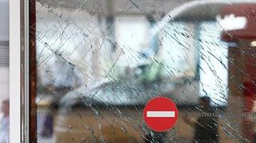 Un hombre observa los cristales rotos de una puerta tras el atentado en el aeropuerto internacional de Atatürk en Estambul.