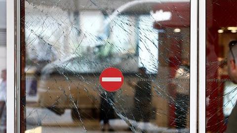 Un hombre observa los cristales rotos de una puerta tras el atentado en el aeropuerto internacional de Atatürk en Estambul.