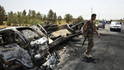 Un soldado iraquí inspecciona varios camiones de ISIS calcinados en 2016/Archivo.