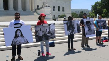 Activistas pro-inmigrantes muestran fotografías de algunos beneficiarios de los alivios migratorios frente al Tribunal Supremo, para presentar a los jueces el "rostro humano" de la crisis migratoria en EEUU. Foto: María Peña/Impremedia