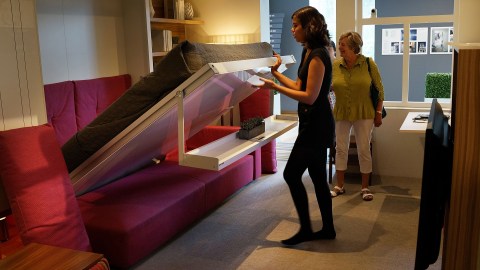 NEW YORK, NY - AUGUST 16: Taylor Jones, a museum intern, shows a 325-square-foot apartment at the Museum of the City of New York on August 16, 2013 in New York City. The exhibit, called "Making Room", was inspired by a contest to design micro-apartments to help ease the affordable housing shortage. Two interns a night get an opportunity to stay in the apartment, designed by Resource Furniture and located inside the museum and then show it to visitors the next day. A new report by the office of Brooklyn Democrat and housing expert Brad Lander, a City Councilman, found that less than 2 percent of all apartments developed in the city since 2005 were deemed affordable housing. New York City Mayor Michael Bloomberg launched "Inclusionary Housing Program" eight years ago in an attempt to get developers to to build larger and taller as long as they also set aside a portion of their apartments for low- to middle-income tenants. (Photo by Spencer Platt/Getty Images)