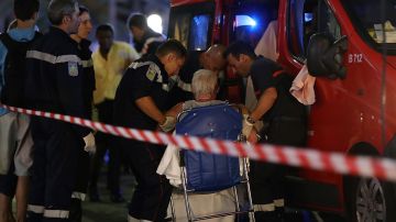 Paramédicos ayudan a una mujer lesionada a entrar en una ambulancia, tras la masacre ocurrida en Niza, Francia.