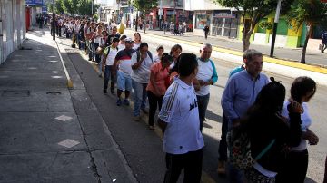 Cientos de personas aguardan en una calle antes de cruzar por el puente fronterizo "Simón Bolívar" entre Colombia y Venezuela, en San Antonio del Táchira, Venezuela.