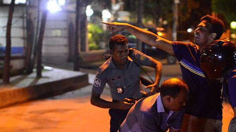 Un hombre herido recibe ayuda en los alrededores del local atacado en Dacca, Bangladesh.