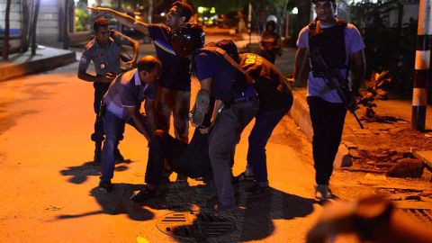 Un hombre herido recibe ayuda en los alrededores del local atacado en Dacca, Bangladesh.