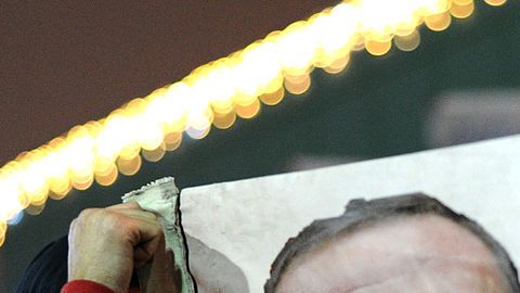 Un manifestante sostiene una pancarta con imágenes del primer ministro turco, Recep Tayyip Erdogan (c) y el clérigo turco con sede en EEUU Gülen (i) durante una manifestación contra el gobierno el 30 de diciembre de 2013 en Estambul.