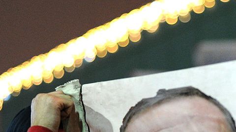 Un manifestante sostiene una pancarta con imágenes del primer ministro turco, Recep Tayyip Erdogan (c) y el clérigo turco con sede en EEUU Gülen (i) durante una manifestación contra el gobierno el 30 de diciembre de 2013 en Estambul.