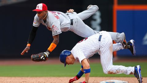 Brandon Nimmo, de los Mets, barre fuerte en la segunda base sobre Adeiny Hechavarría, de los Marlins.